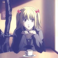 a woman sitting at a table with a cup of coffee