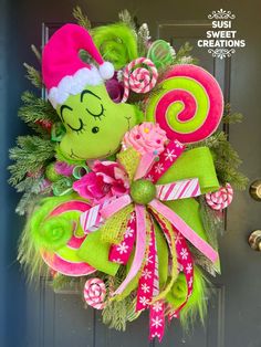 a christmas wreath with candy canes and a green elf's hat on the front door