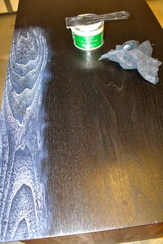 a wooden table with a green cup on top of it and some tissue paper next to it