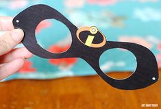 a person holding up a pair of scissors with the handle cut out to look like an eye