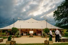 a large white tent set up for an outdoor wedding