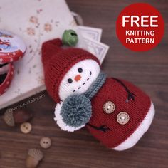 a knitted snowman doll sitting on top of a wooden table next to buttons