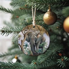 an ornament hanging from a christmas tree with an elephant painted on the front