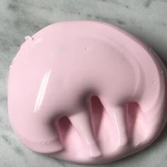 a pink toothbrush holder sitting on top of a marble counter