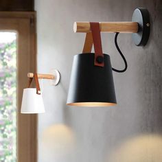 two lamps are hanging on the wall next to each other