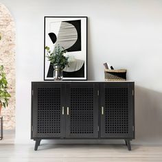 a wooden cabinet sitting next to a potted plant