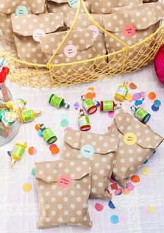 small brown bags filled with candy sitting on top of a table next to confetti