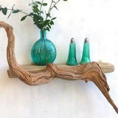 three green vases sitting on top of a wooden shelf