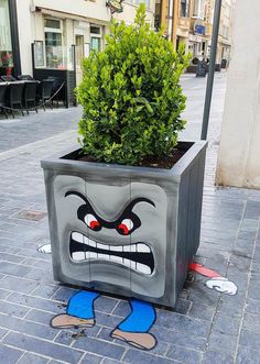 a potted planter with an angry face painted on it's side and legs