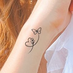 a woman's arm with a tattoo on it that has a butterfly and heart