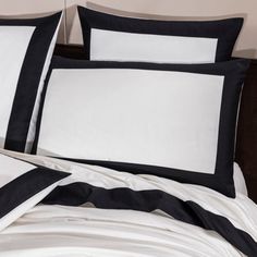 the black and white bedding has two pillows on top of it, along with an empty pillow case