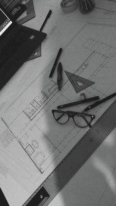 a table topped with glasses and pencils next to a laptop computer