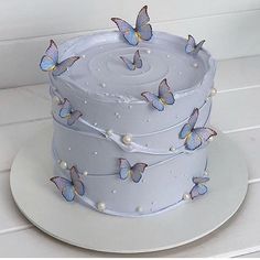 a white cake with blue butterflies on it