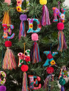 a christmas tree with colorful ornaments hanging from it's branches and the word joy spelled out