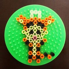 a green plate topped with lots of different colored beads