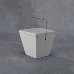 a white toilet sitting on top of a gray floor next to a wall with a stick sticking out of it