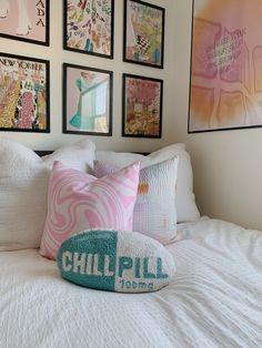 a bed with pillows and pictures on the wall