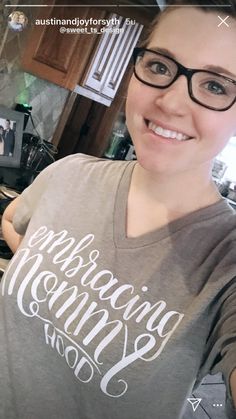 a woman wearing glasses taking a selfie in the kitchen