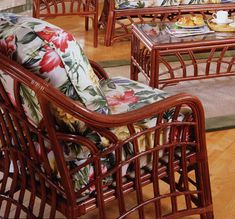 a living room with wicker furniture and flowers on the couch, coffee table and chairs