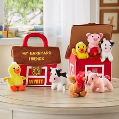 several farm animals are sitting on a table next to a red toy barn with a sign that says, my backyard friends