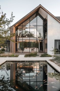 a house with a pool in front of it and lots of windows on the side