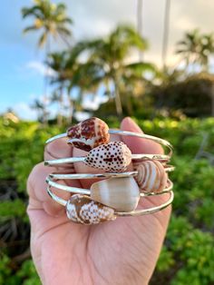 Customize your own Hawaiian shell bangle! This listing is for *ONE* STERLING SILVER bangle that is made to order for you. Turn around time for this will be approximately 2-3 weeks. Sterling silver is safe to wear daily, wear in the water and shine as needed--it will never lose its color. (Note: do not wear sterling jewelry into any type of hot tub--the chemicals will react and affect the metal). Prices for the shells vary depending on rarity. I use only the best shells for my bangles--when you p Adjustable Bangle For Beach, Silver Hand-wrapped Bracelets For Beach, Silver Hand-wrapped Bracelet, Nickel-free Bangle Bracelet For Beach, Nickel-free Bangle Bracelets For Beach, Stackable Beach Bracelet Jewelry, Stackable Bracelet For Beach, Stackable Bangle Bracelets For The Beach, Stackable Beach Bracelet