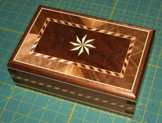 a wooden box sitting on top of a cutting board with a star in the middle