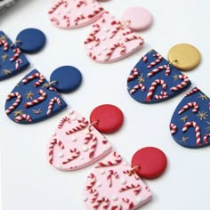 some very pretty colorful earrings on a white table with red, white and blue decorations