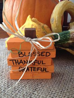 a wooden block with words on it sitting next to a pumpkin and some other items