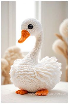 a knitted white duck sitting on top of a table