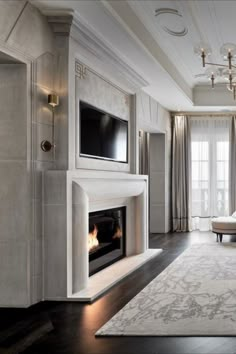 a living room with a couch, fireplace and tv on the wall in front of a large window