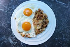 two fried eggs are on top of hash browns