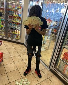 a person standing in front of a store holding a fan and some cash bills on the floor