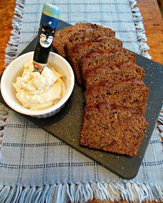 sliced loaf of banana bread next to bowl of ice cream and bottle of booze