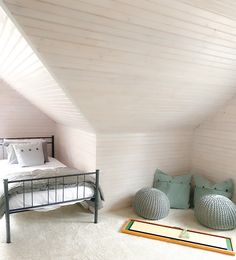 an attic bedroom with white walls and carpet