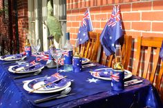 the table is set with blue and white plates, silverware, and australian flags