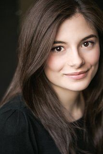 a woman with long brown hair smiling at the camera