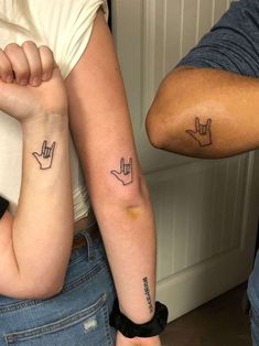 two people with matching tattoos on their arms