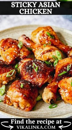 chicken wings on a plate with sesame seeds and garnishes in the background