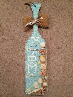 a bottle with seashells on it and a bow