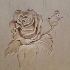 a carving of a rose on a wooden surface