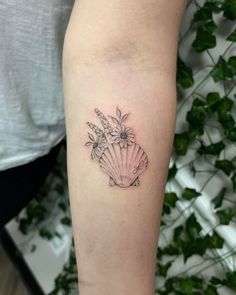 a woman's arm with a tattoo on it and flowers in the center,