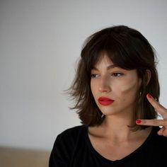 a woman making the peace sign with her hand and red lipstick on her lips,