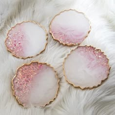 three pink and gold coasters sitting on top of a white rug