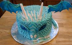 a birthday cake made to look like a dragon's head with spikes and wings