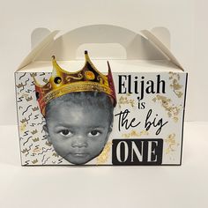 a box with a little boy wearing a crown on top of it's head