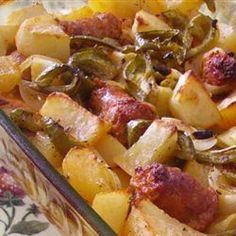 a casserole dish with sausage, potatoes and peppers