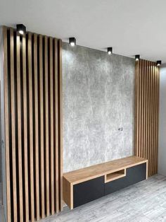 an empty room with wooden slats on the wall and a tv stand in front of it