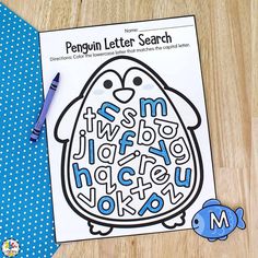 a penguin letter search is on the table next to a blue polka dot tie and pen