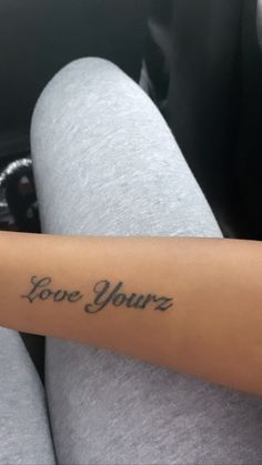 a woman's arm with the words love yourz tattooed on her left arm